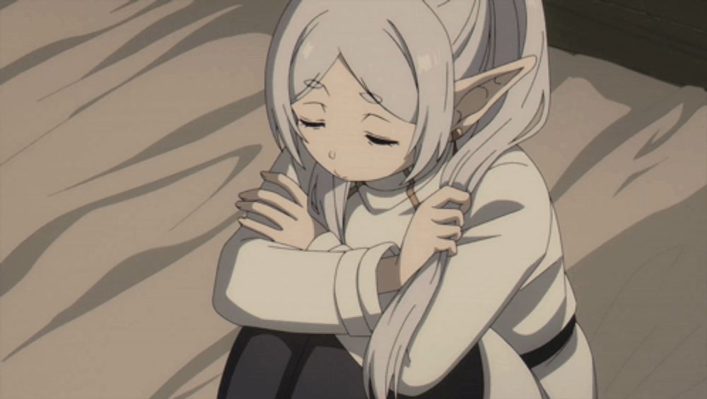 a girl with long white hair and elf ears is sitting down