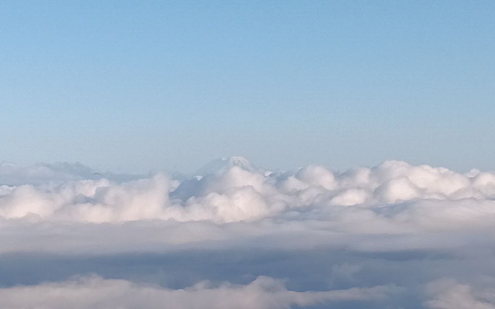 Mt St Helens barely visible above a big bank of fog and clouds