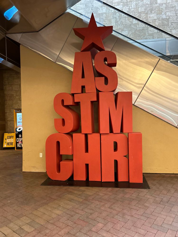 A jumble of giant letters near an escalator, with a star on top. Meant to spell out “Christmas” but it reads like:

AS
STM
CHRI