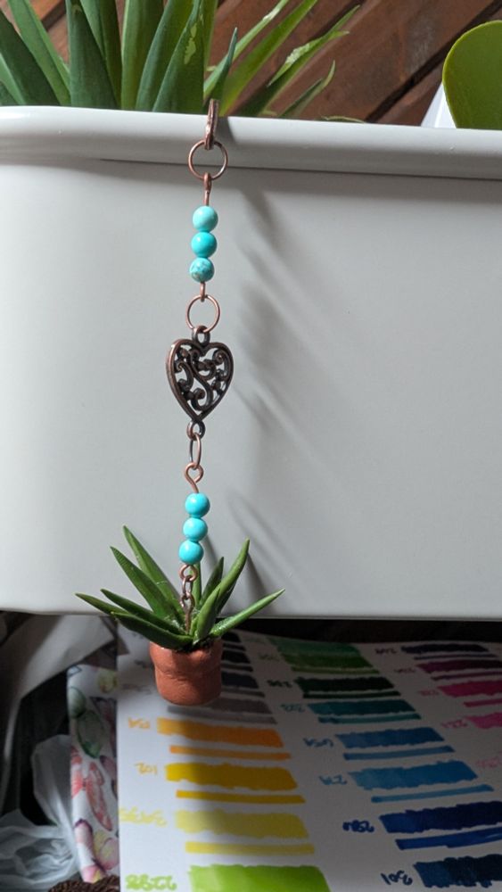 handmade copper bookhook with polymer clay potted plant turquoise beads and a copper filigree heart