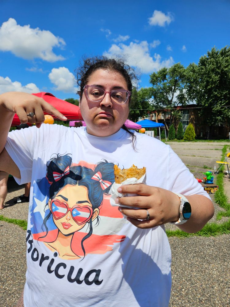 Jenna pointing at a half eaten empanada 