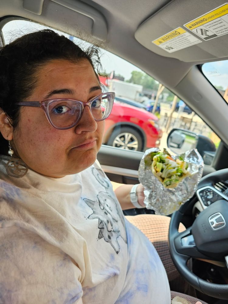 Jenna sitting in a car holding a gyro 
