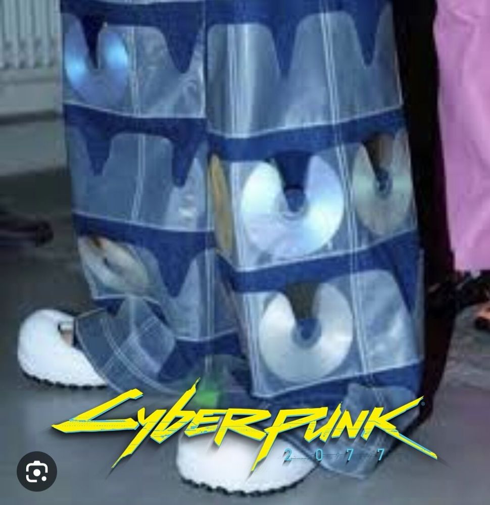 Some absolutely mad genius of fashion seems to have blended the 90s CD flip case with gigantic JNCO jeans, to bewildering and marvelous effect. I have added at the bottom the Cyberpunk 2077 game title.