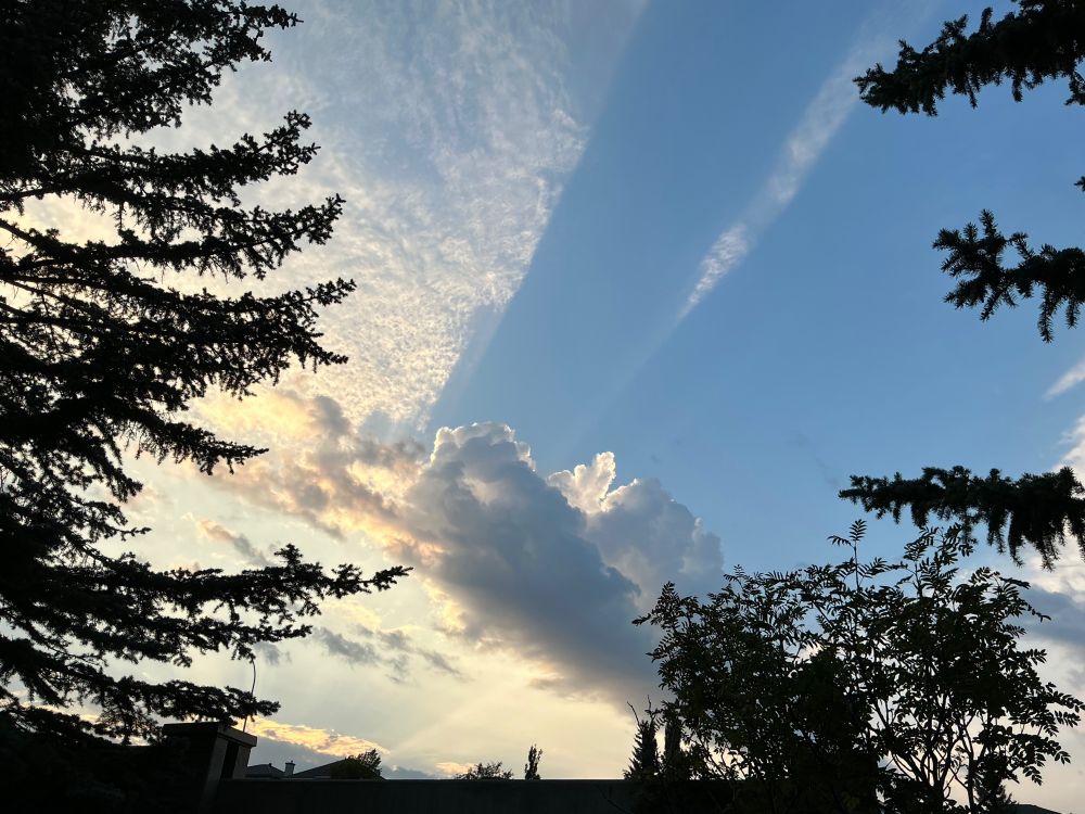 Photo of a cumulus cloud casting a shadow blocking the high level (cirrus?) clouds above.