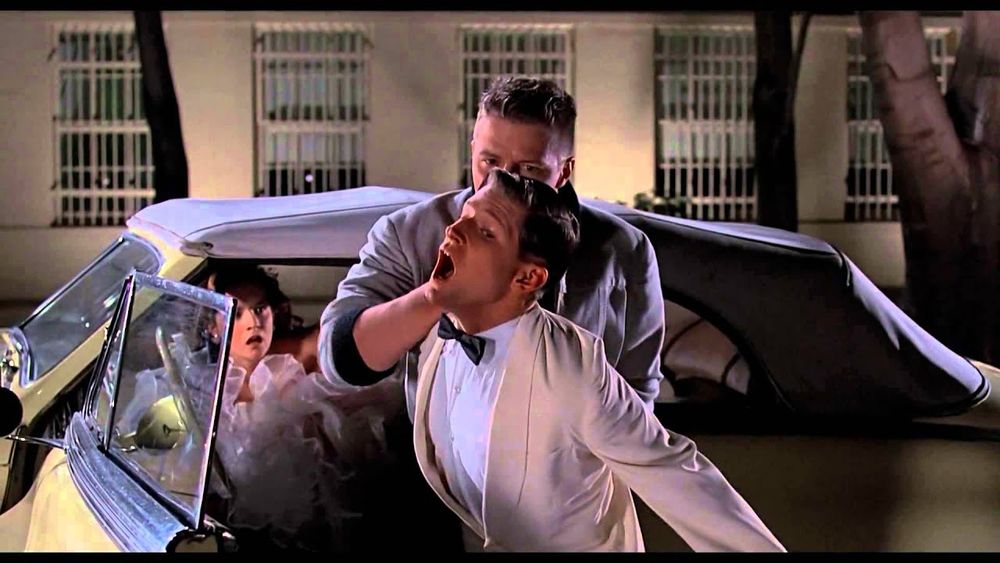 Scene 2: Biff attacks George, putting his shoulder in a painful lock. Lorraine is in the car behind them watching the scene in horror.