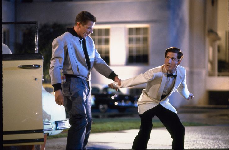 Scene 3, outside the car. Biff is laughing while George composes himself and looks back up at Biff behind him.