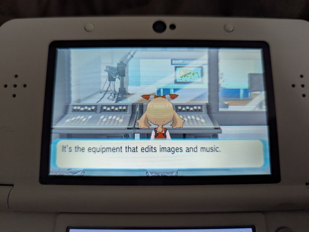 Photo of a 3DS top screen while playing Pokemon Alpha Sapphire. Main character is sitting at the audio/video control board in the Mauville TV station.