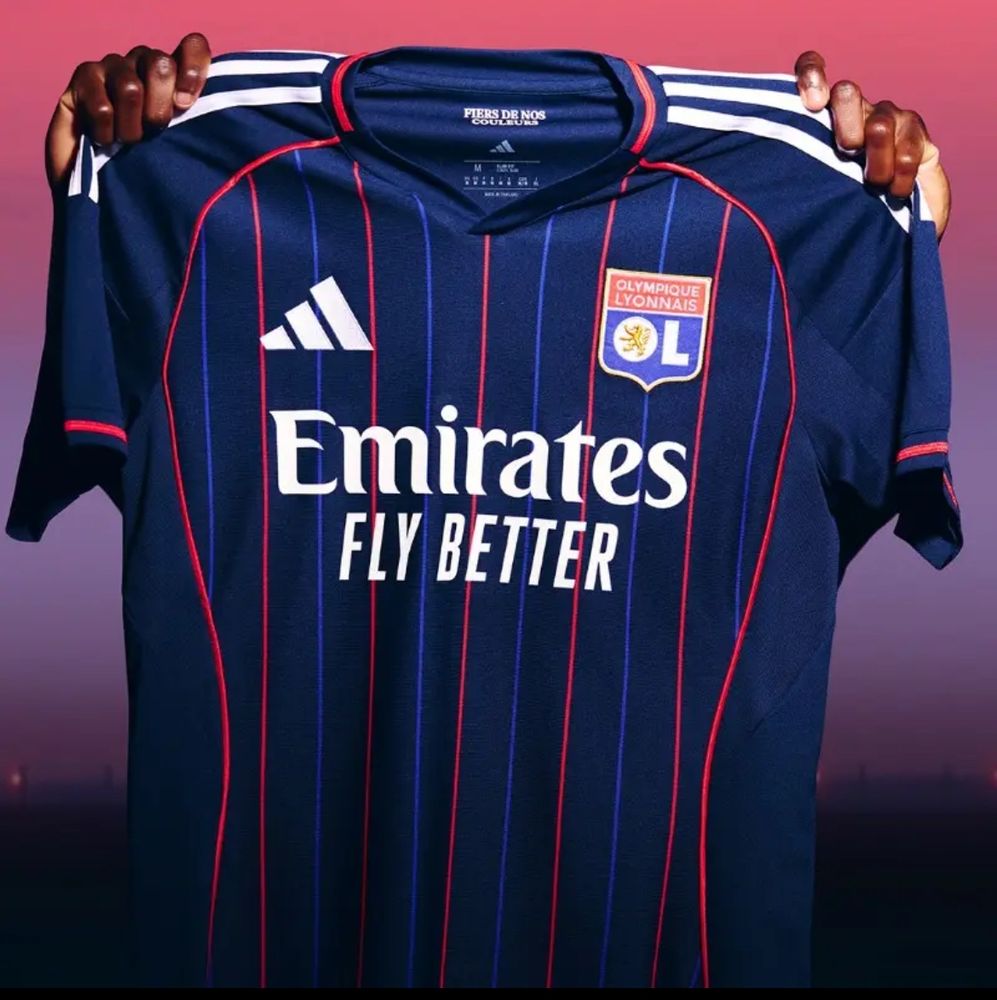 Maillot extérieur de l’OL 2025/2026 bleu foncé avec des bandes bleu clair et rouge