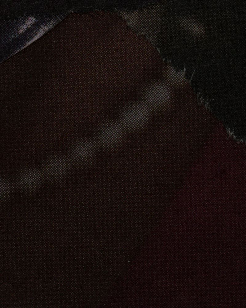 A dark newsprint collage of diffuse imagery, with a woman's torso and partial head in the center, with another similar woman's torso above it, flipped upside-down — closeup of a pearl necklace from the background.