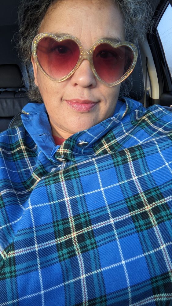 Silly me sitting in the car wearing a blue wool capelet and gold glitter heart sunglasses. I am smiling a little bit. 