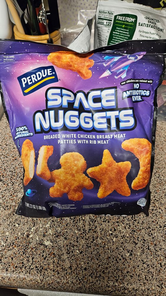 Image of an unopened, 27oz bag of space themed Perdue chicken nuggets on a kitchen counter top.
