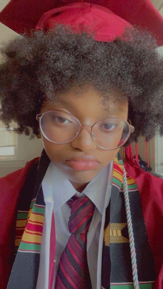 Me in my outfit I wore for graduation last year. Maroon cap and gown, white shirt, maroon tie, black grads matter scarf and a ribbon with the trans flag colors on it.