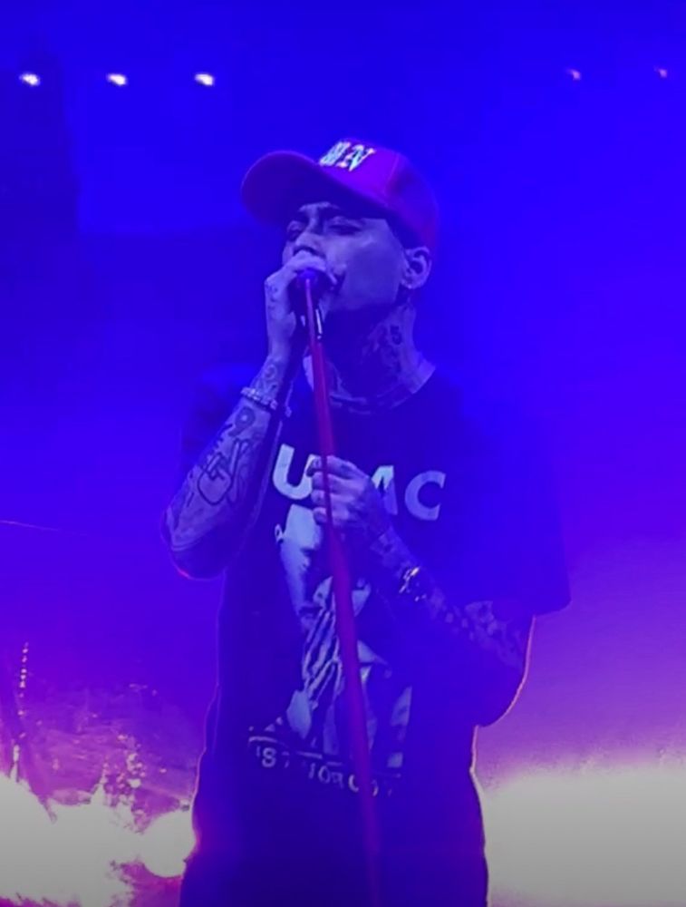 Zayn Malik on stage at Leeds wearing a TUPAC black Tshirt that says Trust No One