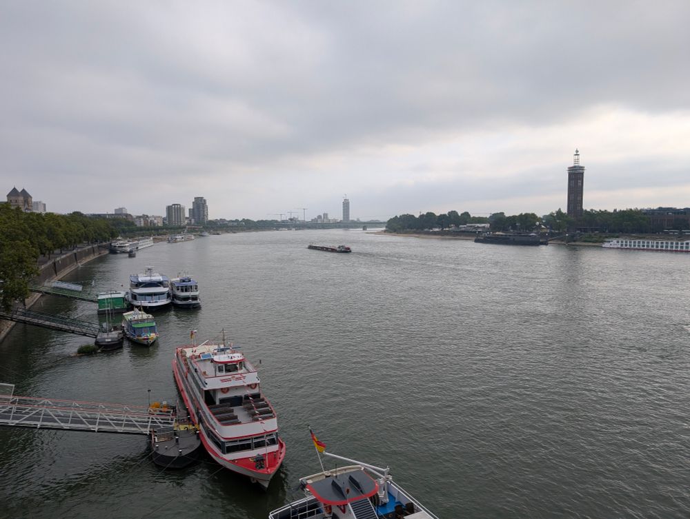 Picture of the Rhine river with several boats docked on the left side bank