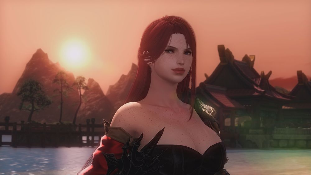 Elise Solara, a red-haired freckled woman standing on a beach. The sun is setting behind her as she gives a slight smile into the camera.
