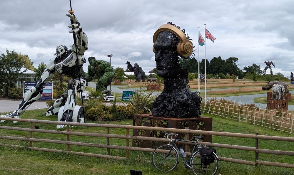 Photo of sculptures : a head, a Transformer, a Hulk, a gorilla, and more ... with my bike in the foreground.