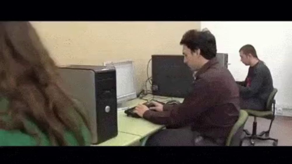 a man sits at a desk with a dell computer