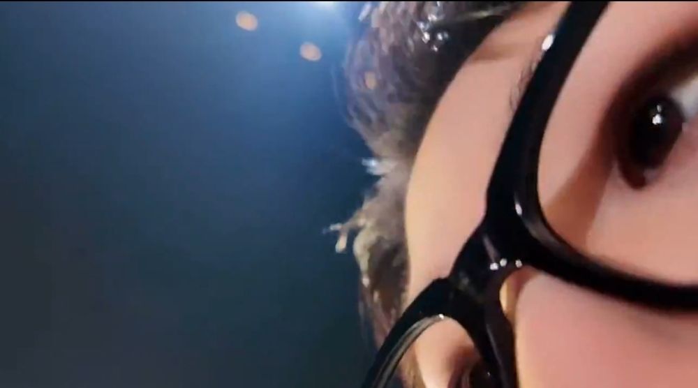 Screenshot of an up close shot of woozi's face, only showing a part of his forehead and glasses