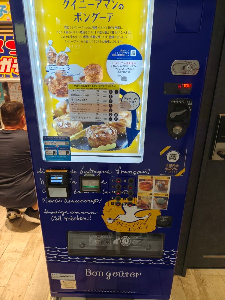 Un distributeur automatique de kouign aman dans la gare d'Hiroshima. Marque "Bon goûter" avec des phrases vaguement en français.