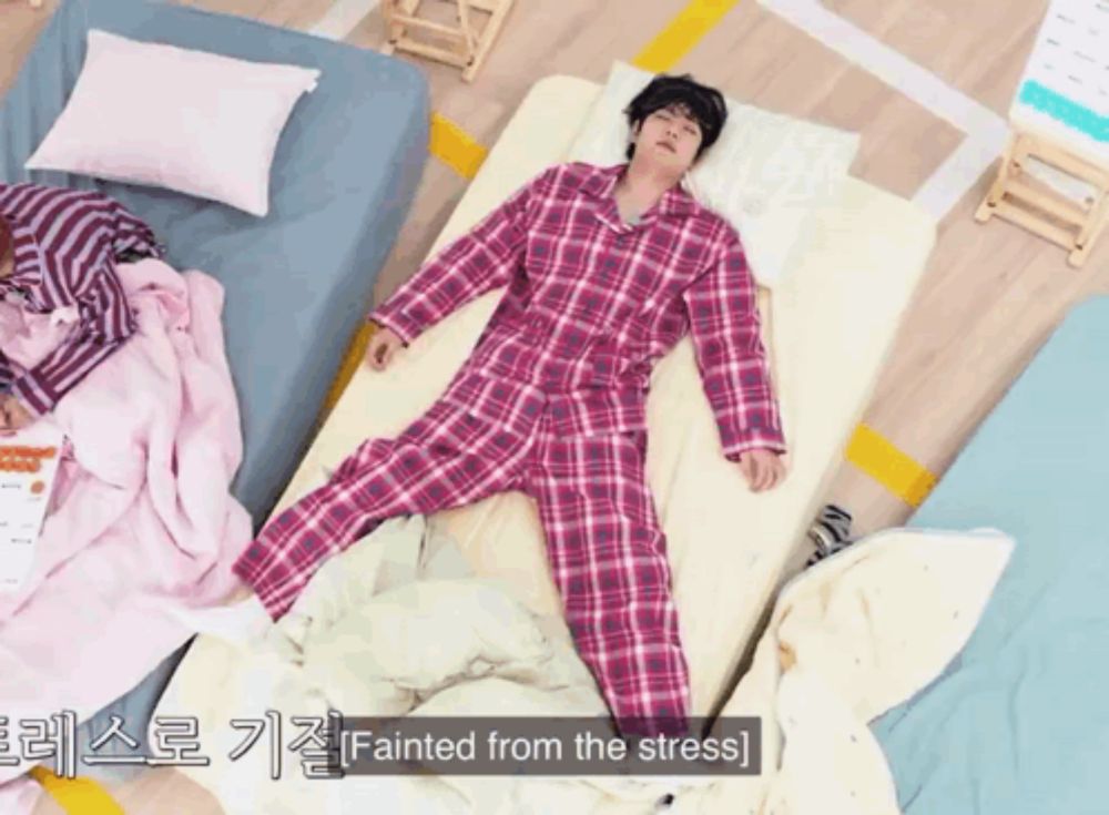 a man in plaid pajamas laying on a bed