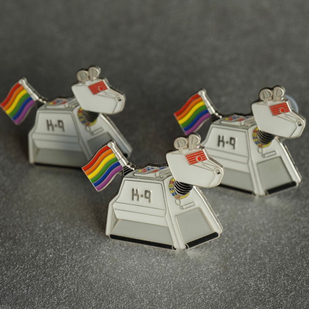 Pin badges of robot dogs waving a rainbow flag form their tails. 