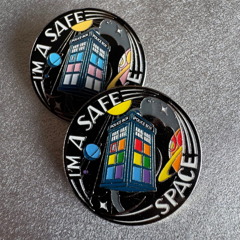 A pin badge saying “I’m a safe space” featuring pride coloured police boxes. 