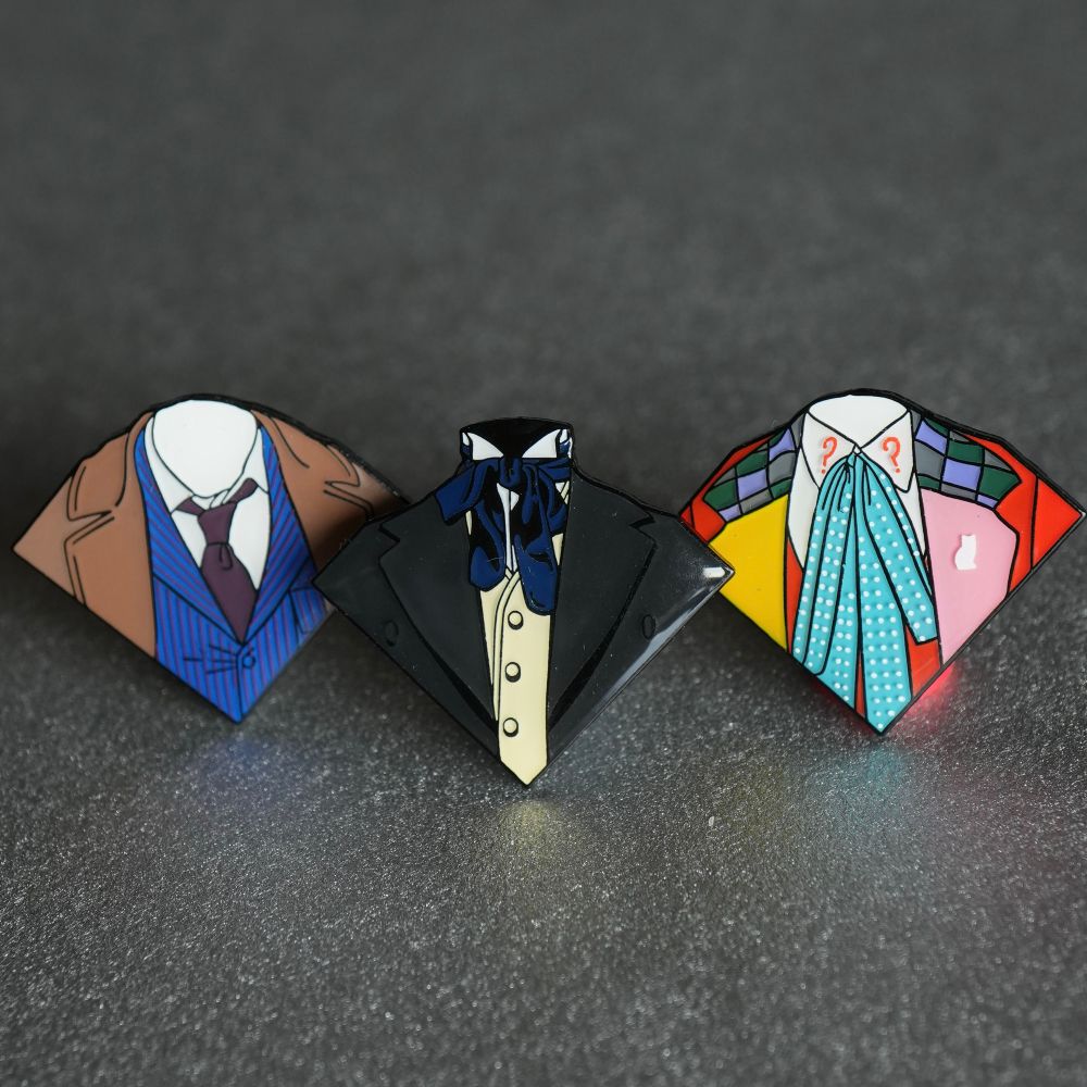 Three pins of outfits worn by the tenth, first and 6th doctors. 