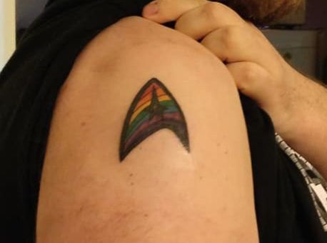 An arm showing a rainbow Star Trek logo. 