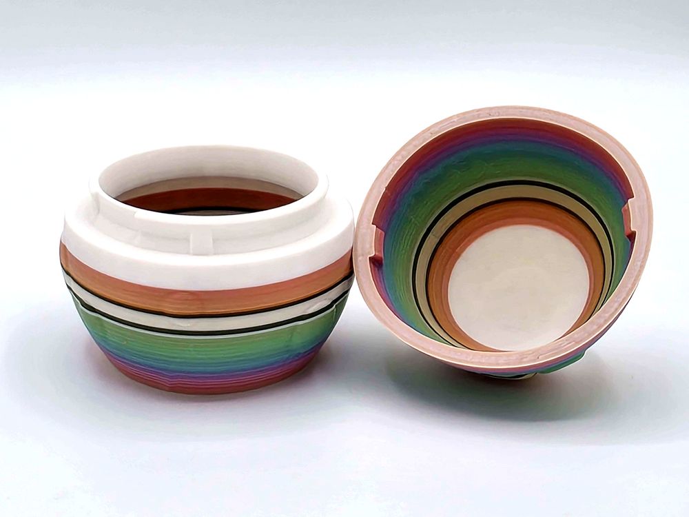 A large egg that splits in half so that you can hide your treasures in it! It's printed in random stripes of white, black, and a rainbow gradient