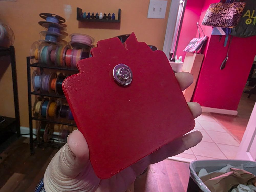 The back, showing a small magnet fastener. You can use it to fasten the name tag to your clothing without a pin!