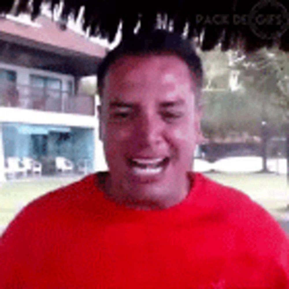 a man in a red shirt is laughing and smiling .