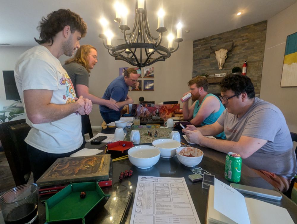 People sit around a table playing dungeons and dragons.