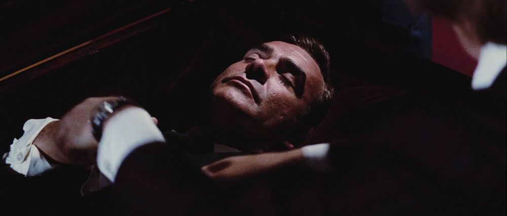 A man in a casket, arms folded