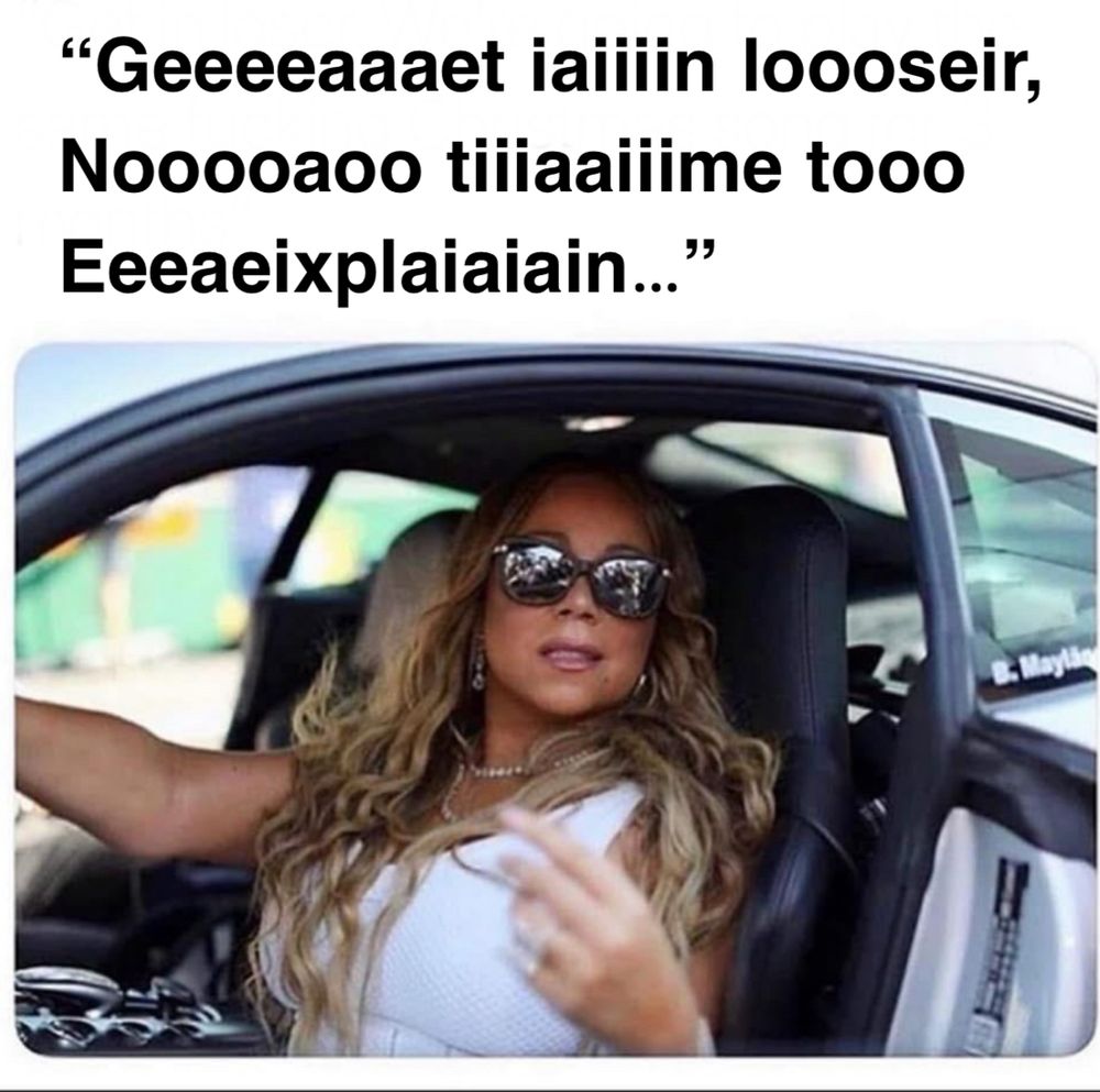 Mariah Carey sitting in a car saying get in loser no time to explain but lots of extra vowels, as per her weird singing voice