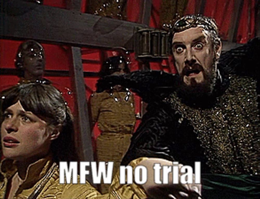 a man with a beard and a crown stands next to a woman with the words mfw no trial on the bottom