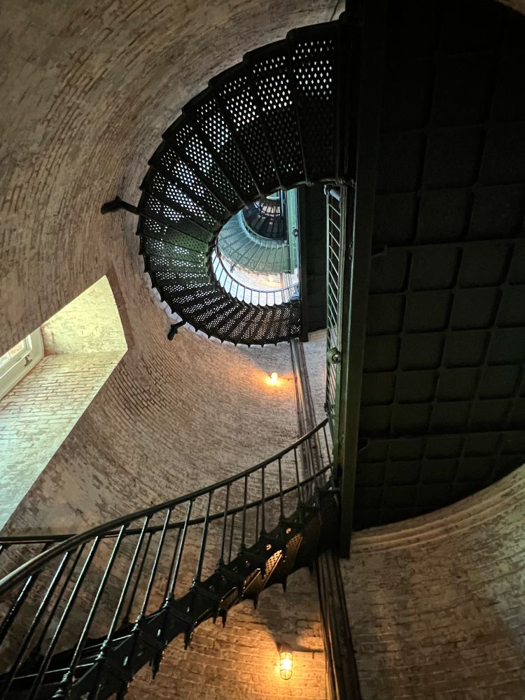 dark painted metal spiral staircase going up the inside of a lighthouse