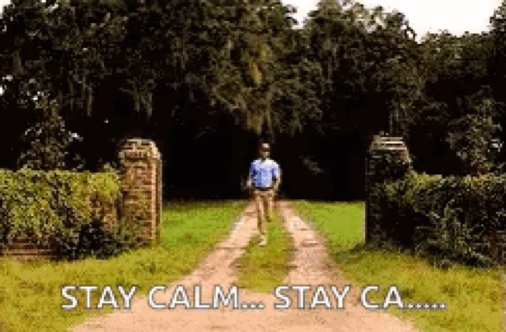 a man is walking down a dirt road with the words `` stay calm ... stay ca ... '' written on the bottom .