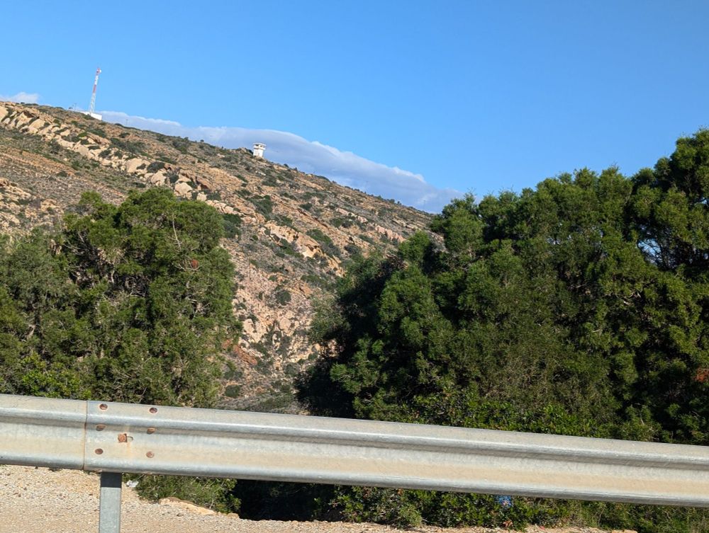 Mountain side in Korbus, Tunisia, mountain, trees and a guard rail. View from the car 