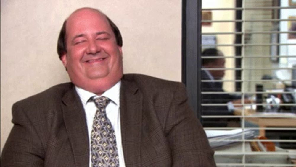 a man in a suit and tie is smiling in front of a window .