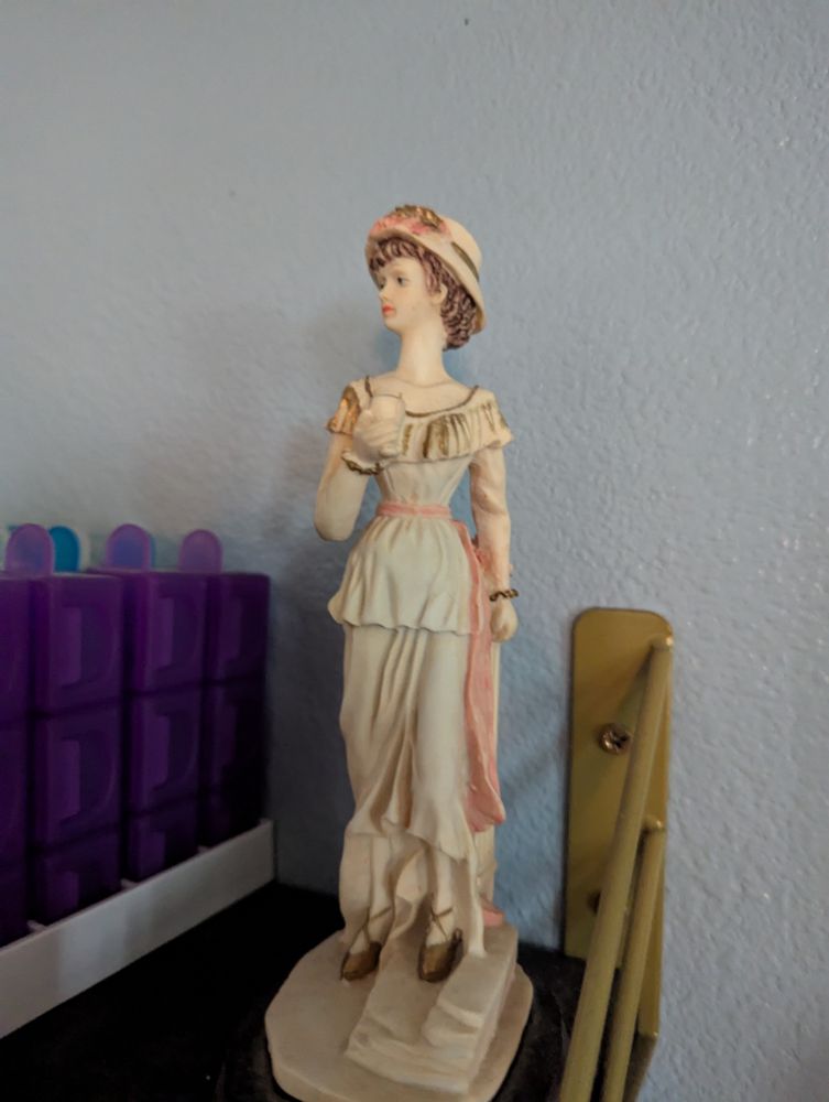A vintage reproduction of a lady. I own two of them. She lives next to my pill case