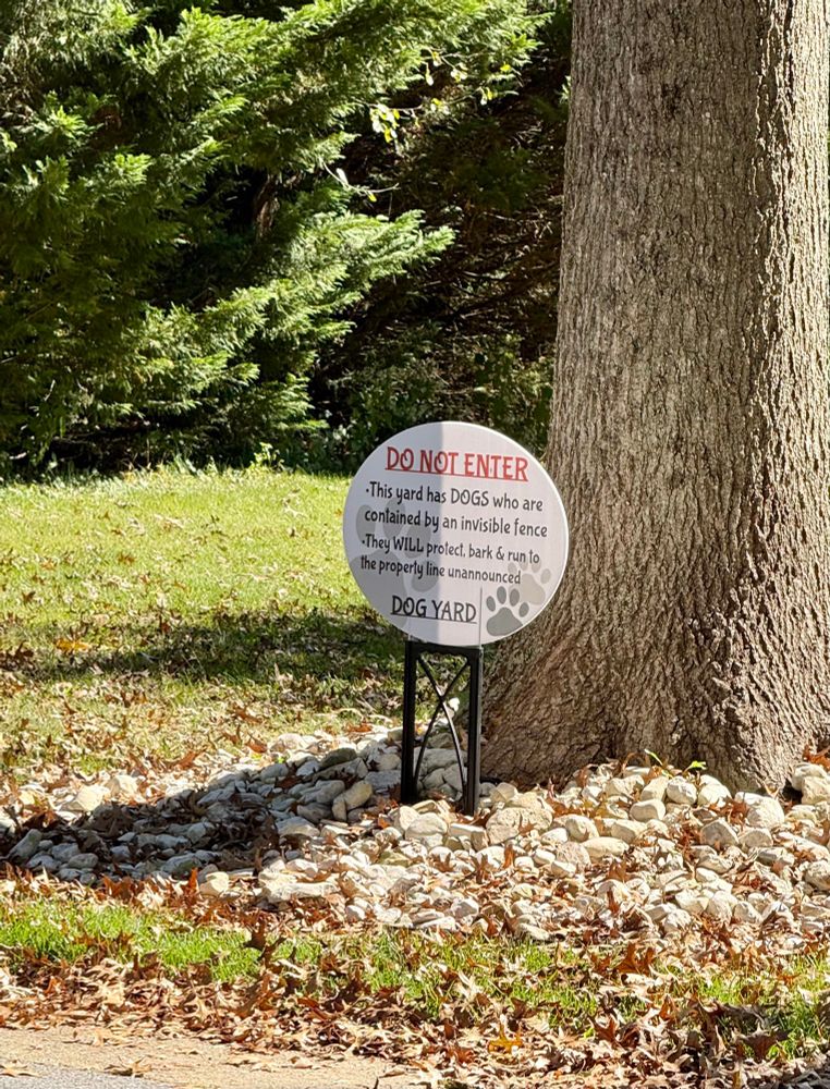A sign warning people not to enter the property because of dangerous dogs.