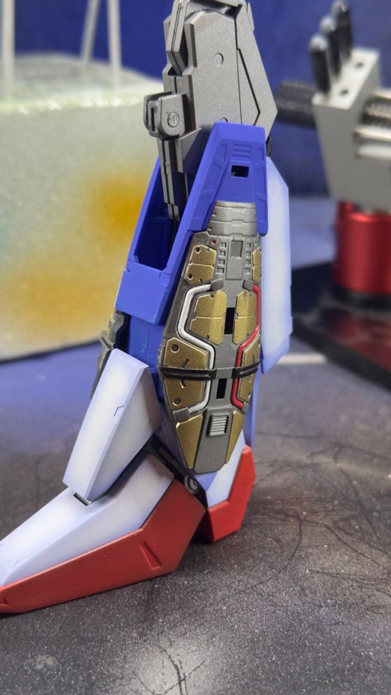 Zeta Gundam leg profile showing thruster engine with gold armor pieces and red and white fuel hoses 