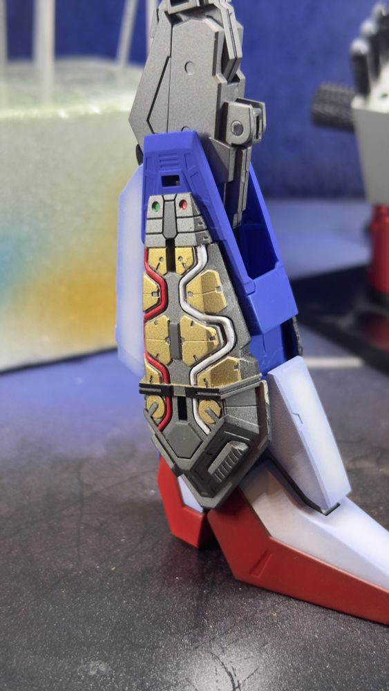 Zeta Gundam leg profile showing thruster engine with gold armor pieces and red and white fuel hoses 