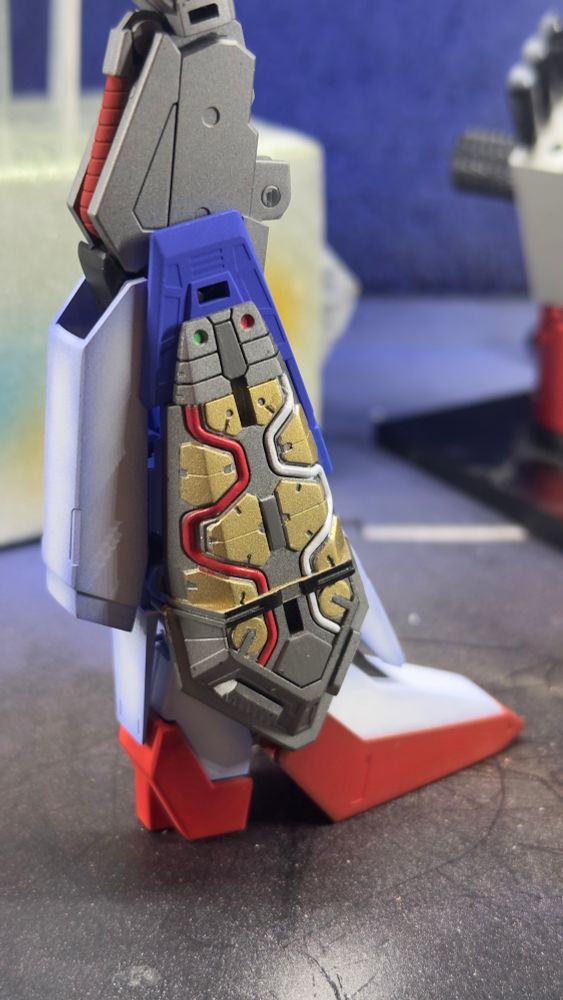 Zeta Gundam leg profile showing thruster engine with gold armor pieces and red and white fuel hoses 