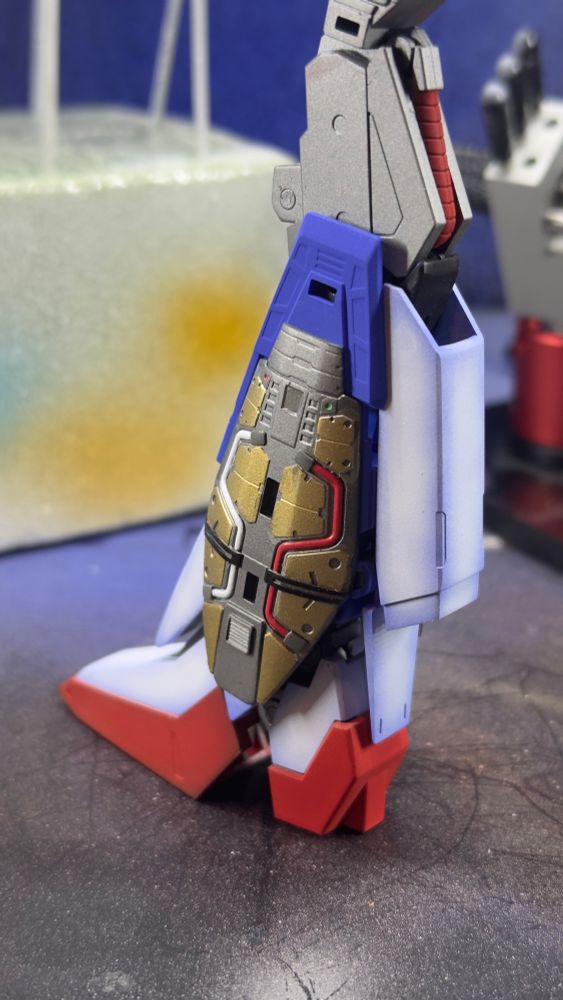 Zeta Gundam leg profile showing thruster engine with gold armor pieces and red and white fuel hoses 