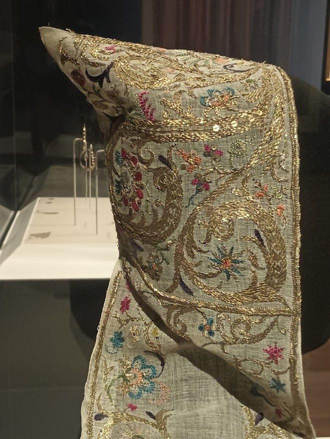 An 1800s Algerian beniqa headdress worn by a Jewish women at the mikveh before her wedding. It is richly embroidered with metallic gold thread and colored flowers. 
