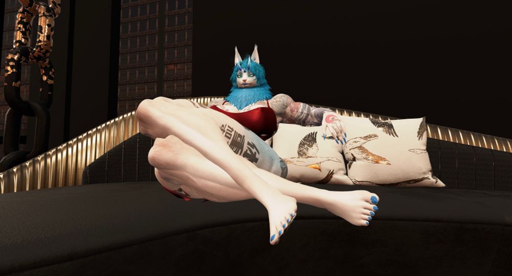 Talia’s chiseled form is resting elegantly on a fancy black and gold couch, her tattoos and lovely form on full display.  