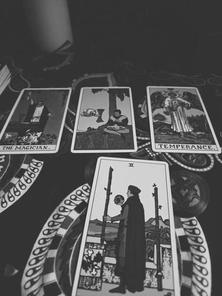 tarot cards in B&W: the magician, 4 of cups, temperance; two of wands. 