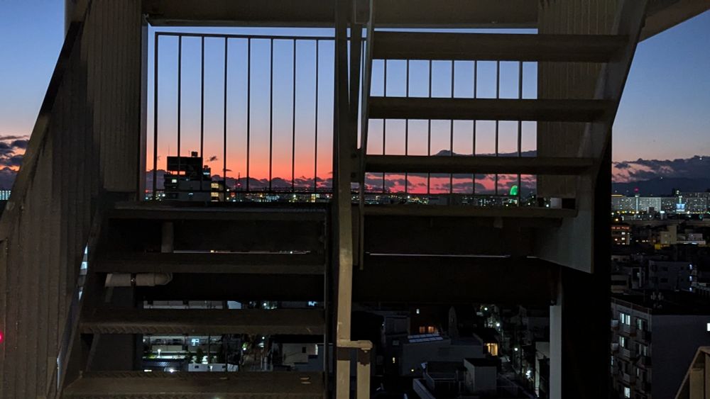 sunset over Osaka seen through the stairs on the exterior of the building