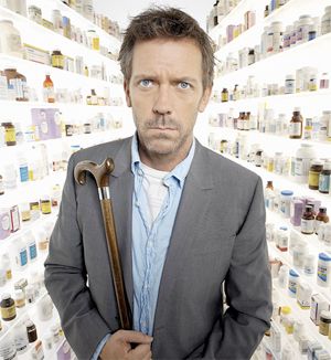 Dr. Gregory House from House, standing in what seems to be a brightly-lit dreamscape with rows and rows of pill bottles